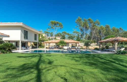 Magalas Apartment | A large table with chairs and a garden furniture with sunbeds