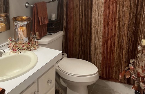 Charlotte Park House | Bedroom with a queen size bed and bath. Shared kitchen and lanai.
