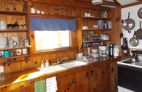 North Sebago Cottage | Classic pine paneled Maine cottage with large sandy beach on Sebago Lake.