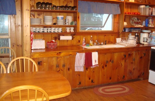 North Sebago Cottage | Classic pine paneled Maine cottage with large sandy beach on Sebago Lake.