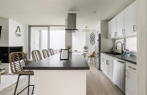 Mission Hills Apartment | Discover the work of modernist architect Homer Delawie at the Hillside Hideaway. This unique downstairs unit reflects his renowned style of simplicity, using large glass areas to seamlessly blend the living space with the natural surroundings.