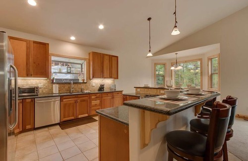 Tahoe Island House | Enjoy the tree-lined yard, spacious deck, and hot tub!