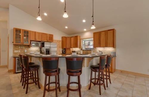Tahoe Island House | Enjoy the tree-lined yard, spacious deck, and hot tub!