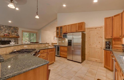 Tahoe Island House | Enjoy the tree-lined yard, spacious deck, and hot tub!