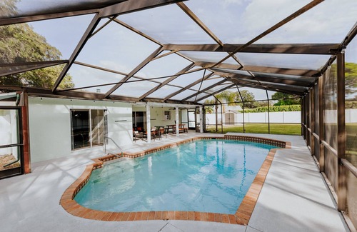 Palma Sola House | LUXE beach getaway 5mins from water. 3xKING BR, large heated pool + new playland