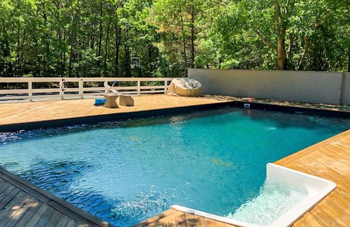 Quogue House | Post-Modern-style home with coastal-style bedrooms, an open-floor plan, a...