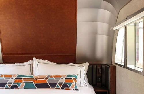 West Fens Hotel | Queen ADA Trailer Stay w/Vinyl Library, Outdoor Pool, Steps to Attractions!