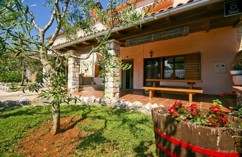 Orihi House | Rustic stone house with sunshade on a fenced property