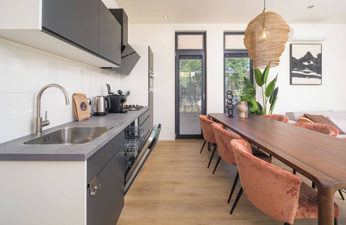 Lieren House | Stylish 6-person home with three bedrooms, a modern kitchen, air conditioning, a cozy outdoor space with a luxury pergola, private hot tub, and a lounge area with an outdoor fireplace. Enjoy comfort and nature in the Veluwe.