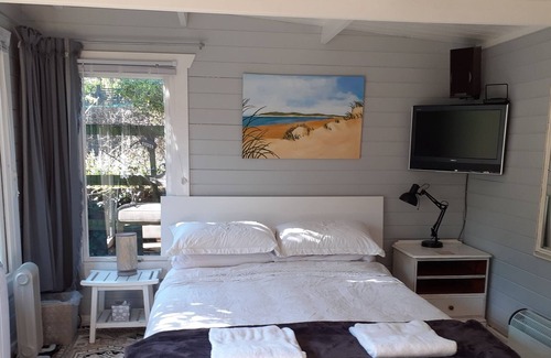 Hastings Cabin | Sunny log cabin set in beautiful peaceful garden . 10mins walk to town and beach