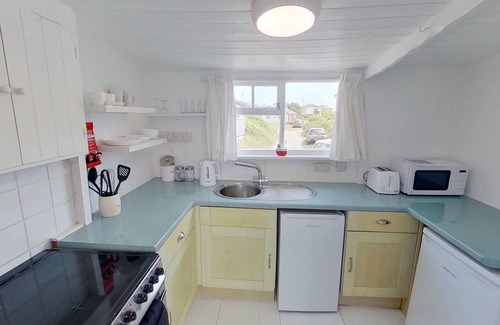 Hayle Ski Chalet | Treville soaks up the sun, which can be enjoyed from the deck with sea views.