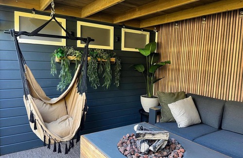 Lieren House | Veluwe Chalet featuring a charming veranda with a fire table.