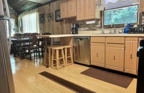 Brookville House | Welcome to your perfect getaway! Nestled on a semi-secluded 2-acre lot, this charming brick Cape Cod is centrally located between Cook Forest and Clear Creek State Parks. Surrounded by trees, this cozy retreat offers a peaceful escape.