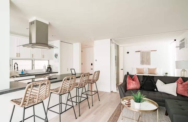 Discover the work of modernist architect Homer Delawie at the Hillside Hideaway. This unique downstairs unit reflects his renowned style of simplicity, using large glass areas to seamlessly blend the living space with the natural surroundings.