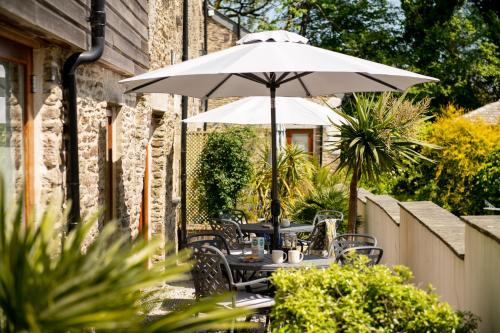 Widegates House | Corn Barn at East Trenean Farm -Luxury Cornish Barn Conversion sleeping 8 with hot tub, private garden, rural views and EV facilities