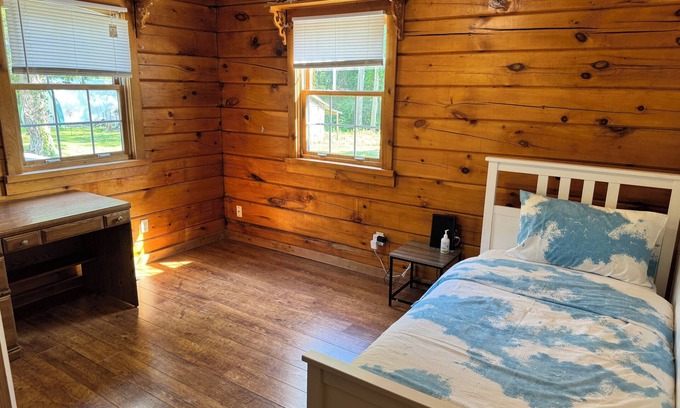 Dunnville House | Serene log home on spacious land with trees and a small farm.