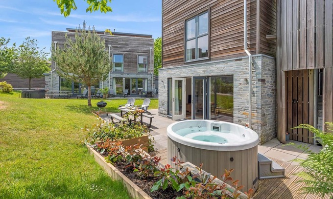 Talland House | Stylish and contemporary pet friendly property featuring a wood-burning stove, patio hot tub and lar
