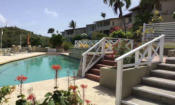 Dickenson Bay Apartment | Swimming Pool- Balcony/Veranda- Sea & Sunset Views