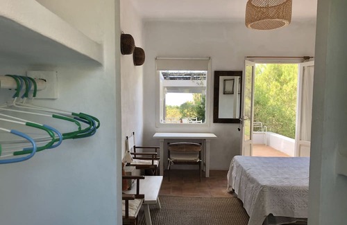 Es Cap de Barbaria House | Formentera. Room immersed in the woods with sea view.